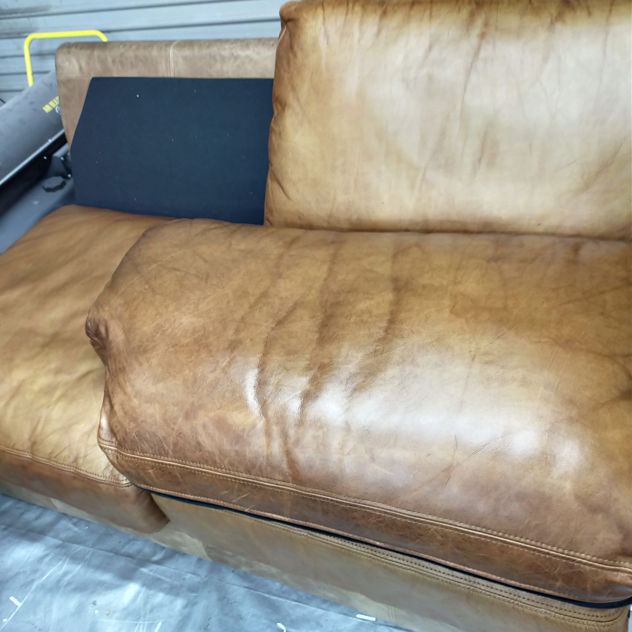 before image of a worn white leather sofa in need of repair